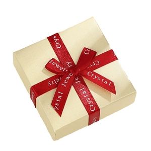 Premium textured beige jewelry gift box with a deep red ribbon bow and lid