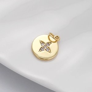 Macro shot of gold circular pendant with a sparkling zircon star set on a white surface