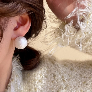 Elegant white acrylic snowball pearl stud earring shown on a model side profile