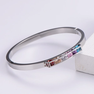 Macro shot of silver open bangle with six rectangular colorful rainbow cubic zirconia stones
