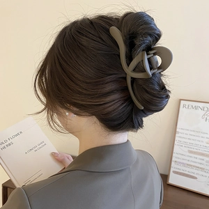 Detail of matte coffee large hair claw clip for long hair styling in elegant setting