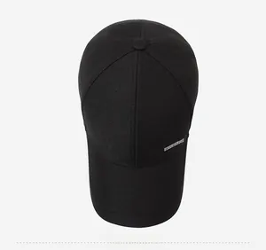 Top down view of black cotton baseball cap showing premium silver metal logo plate
