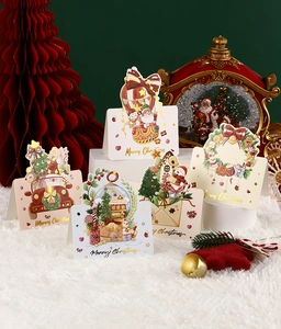 Detailed view of 5 assorted 3D gold-stamped Christmas cards on a white plush surface