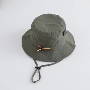 Detail of army green nylon bucket hat showing adjustable orange drawstring and side letter patch