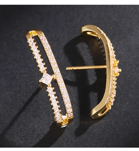 Gros plan détaillé de boucles d'oreilles dorées doubles couches avec zircon carré central
