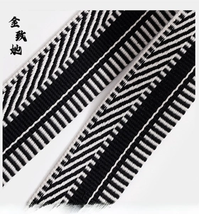 Detail showing black and white geometric jacquard weave shoulder strap with herringbone pattern