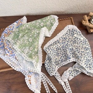 Detailed flat lay of three floral cotton bandanas with delicate white lace trim and ties