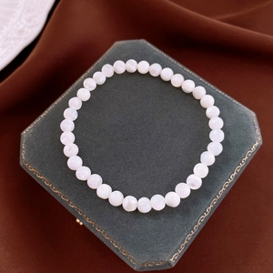Close-up of elegant white shell bead elastic bracelet on green velvet jewelry box