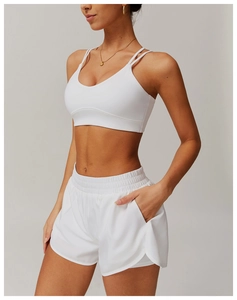 Détail de la brassière de sport blanche à fines bretelles et short taille haute avec poches