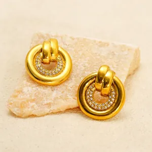Polished 18K gold stainless steel earrings with white rhinestones on a natural stone base