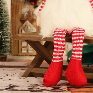 Détail des jambes rayées tricotées et de la barbe douce en fausse fourrure du gnome