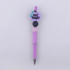 Detail of purple beaded pen featuring a silicone pumpkin with Stay Spooky text