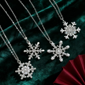 Elegant silver snowflake pendant necklace set with crystals and pearls on green velvet