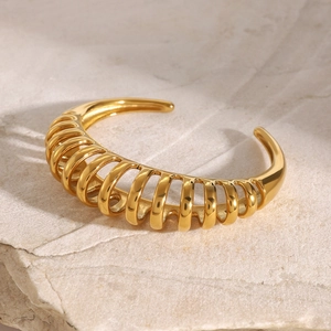 Detailed view of an 18k gold plated stainless steel open cuff with a unique mesh design