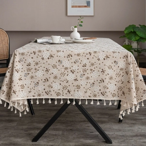 Close-up of linen table runner with floral patterns, dragonflies and fringe details