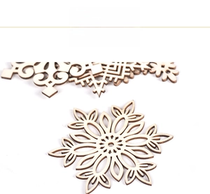 Close-up of laser-cut wooden snowflake ornaments with intricate hollow patterns for DIY