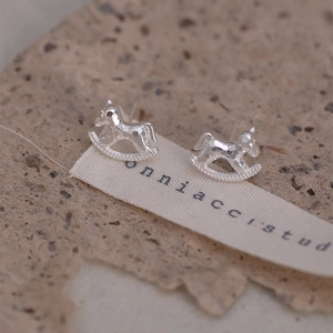 Detail shot of silver rocking horse studs with hammered finish on textured stone surface