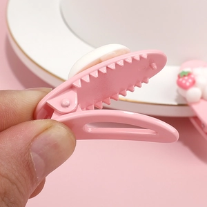Close-up of pink resin hair clips featuring a cute strawberry design and secure toothed grip
