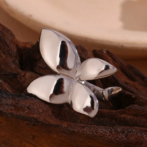 Macro shot of minimalist silver butterfly open ring displayed on textured dark wood base