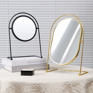 Desktop iron makeup mirror with rotating metal frame on stylish tabletop setting
