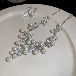 French style pearl and diamond jewelry set with necklace and drop earrings in a white dish