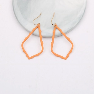 Detailed view of orange teardrop earrings with bamboo texture and gold hooks