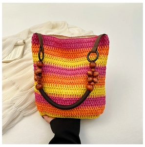 Close-up of rainbow gradient woven straw bag with decorative large wooden bead handles