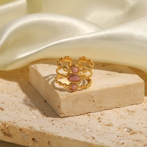 Nahaufnahme der goldenen mehrlagigen Ringe mit drei rosa ovalen Edelsteinen