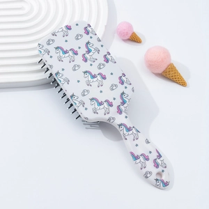 Detail of white air cushion hairbrush with colorful unicorn patterns and black bristles