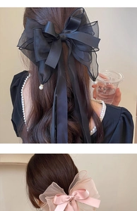 Detail of oversized layered satin bow hair clips with delicate pearl embellishments