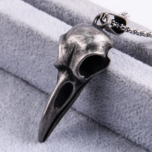 Macro shot of gothic raven skull pendant with vintage dark grey textured metal finish