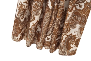 Gros plan sur l'imprimé cachemire marron et le plissé de cette robe longue