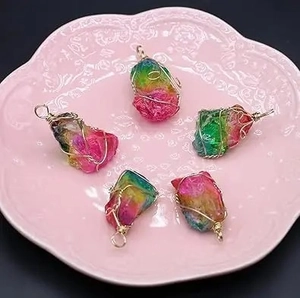Handmade wire-wrapped rainbow crystal stone pendants with golden wire on a plate