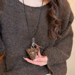 Detailed close-up of brown plush triangle pendant necklace with silver metal fringe