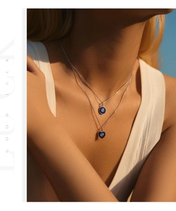 Detail of layered S925 silver necklace with blue enamel heart and round pendants