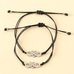 Handmade woven heart and infinity stainless steel couple bracelets on beige background