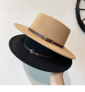 Detail of wool fedora hats with leather buckle bands in camel and black colors