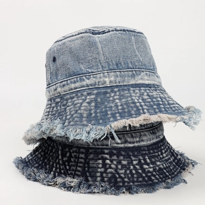 Dettaglio dei bordi sfrangiati e trama denim lavata su cappelli da pescatore