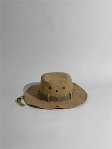 Close-up of khaki sun hat featuring adjustable chin strap and metal ventilation eyelets