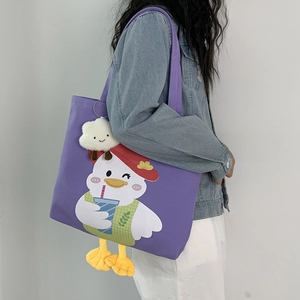 Detail view of purple canvas tote bag with cartoon duck print and plush feet decoration