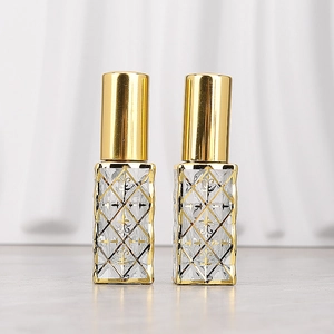 Detail of 12ml glass perfume bottles with golden diamond pattern and metallic caps
