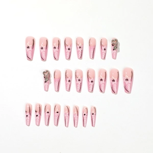 Faux ongles French roses avec motifs de fleurs blanches et strass en forme de cœur