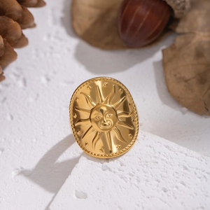 Artistic close-up of vintage sun face ring on white stone with autumn decorations