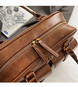 Detail view of premium smooth metal zipper and brown leather texture of a bowling bag