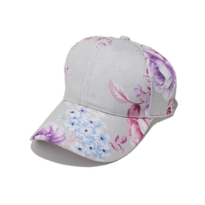 Detail view of linen baseball cap with purple and pink floral print on light grey fabric