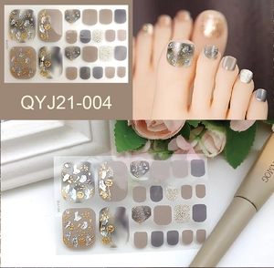 Detail showing gold foil and glitter floral patterns on gray summer toe nail stickers