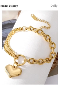 Detail of gold double-layer chain bracelet with heart pendant and lobster clasp
