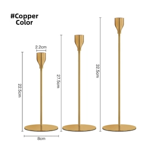 Three-piece gold metal candle holder set in varied heights with brushed brass finish