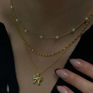 Elegant multi-layer gold necklace for women featuring a bow pendant and pearl details