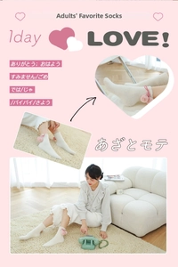 Detail of white plush socks featuring cute pink pom-poms and bows for winter